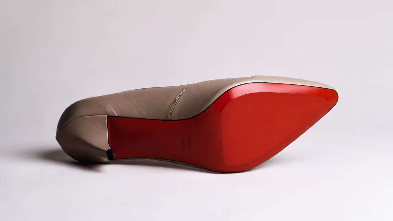 High-heel shoe with a red outsole visible against a contrasting upper color.